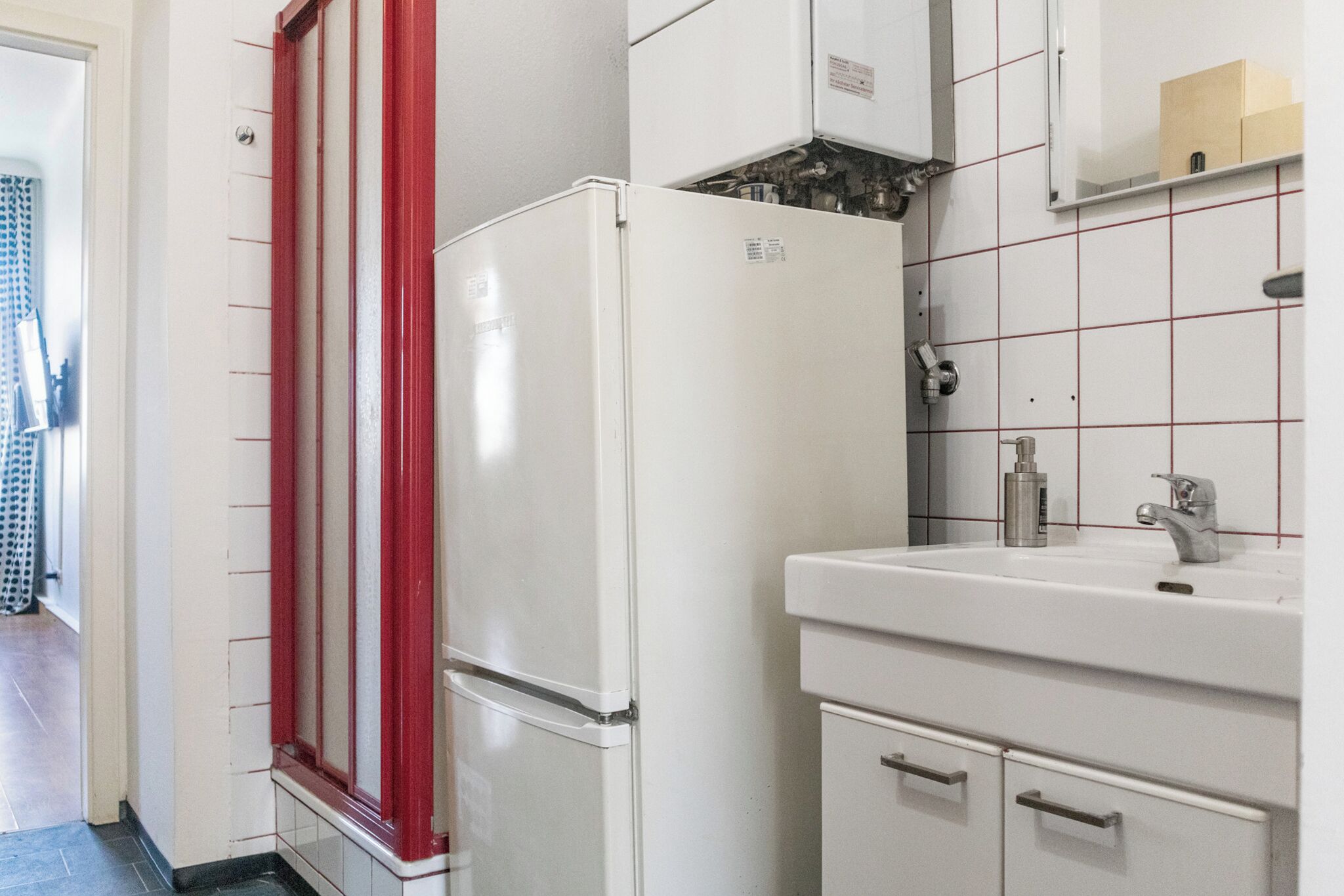 A compact kitchen with a white refrigerator, a sink, and a cabinet.