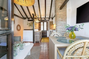 A dining area with a table, chairs, and a vase of flowers.