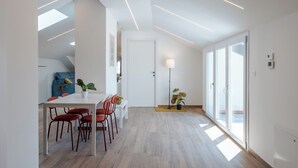 A modern dining area with a white table and red chairs, a blue sofa, and a potted plant. - Chieri - The den of dreams with panoramic terrace (Chieri)