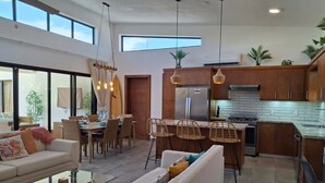 Une cuisine moderne avec des meubles en bois, un réfrigérateur en acier inoxydable et une cuisinière à gaz.