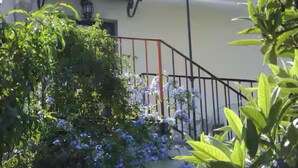 A staircase with a metal railing leading to a building with a tiled roof.