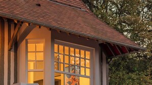 A two-story building with a balcony, a staircase, and a window with a view of a person. - Villa des Rêves: Luxury in Villers, Pool, Jacuzzi & Padel court, A/C, close to Deauville (Villers-sur-Mer)