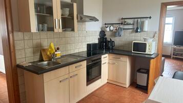 Eine Küche mit Spüle, Herd, Mikrowelle und Schränken.