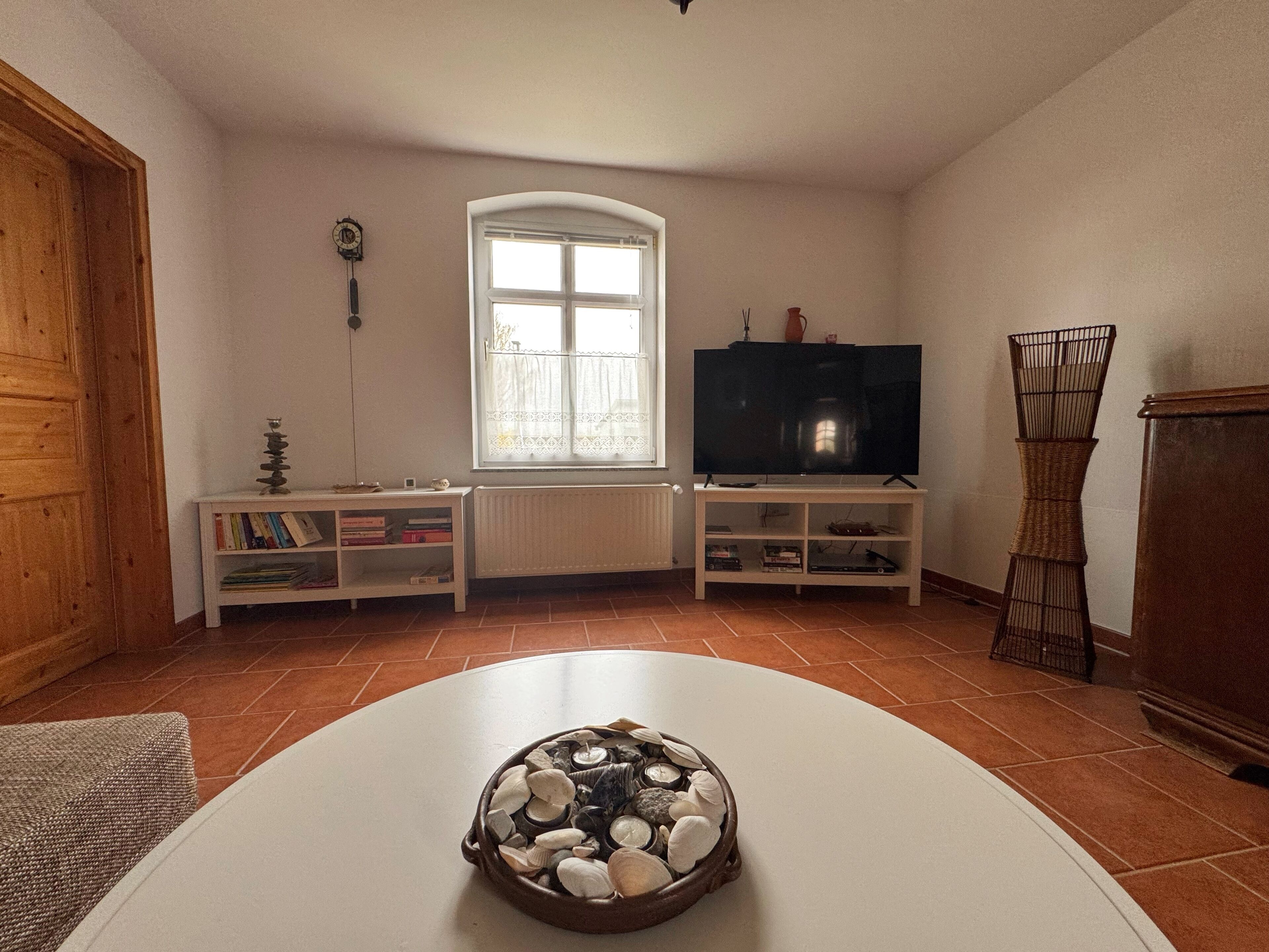 Ein Wohnzimmer mit Kamin, Fernseher und Bücherregal.