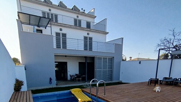 A modern house with a swimming pool, wooden deck, and outdoor seating area. - DALT DES PADRÓ (Muro)