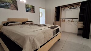 Un dormitorio con cama, armario y puerta.