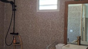 A bathroom with a shower, a sink, and a window. - Échappée Belle in the West Indies (Port-Louis)