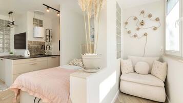 A modern bedroom with a bed, bedside table, and a decorative wall piece.