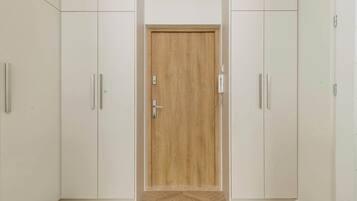 A room with a wooden door, white cabinets, and a herringbone-patterned floor.