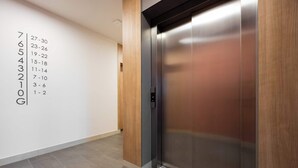 Un ascensor con detalles metálicos y un panel de madera en el lateral.