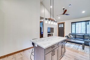 A modern kitchen with a marble countertop, wooden cabinets, and a built-in oven.