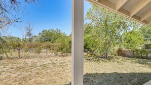 Un espacio al aire libre cubierto con vistas a un campo seco y árboles.