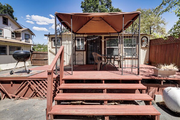 A covered patio with a swing set, a grill, and a wooden deck leading to a house. - Watefront Getaway w/ Mtn Views & Dock in Clearlake (Clearlake)