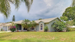 A two-story house with a front porch, a lawn, and a variety of plants and trees. - 7 Mi to River & Ocean: Family Getaway in Sebastian (Sebastian)
