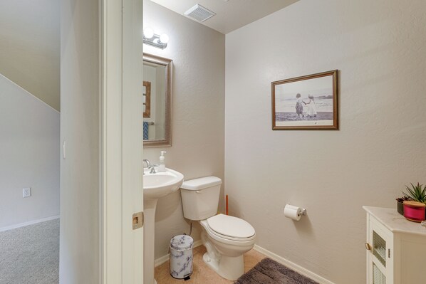 A bathroom with a toilet, sink, and mirror. - 1 Mi to Golf: Lake-view Condo w/ Pool in Chandler! (Chandler)
