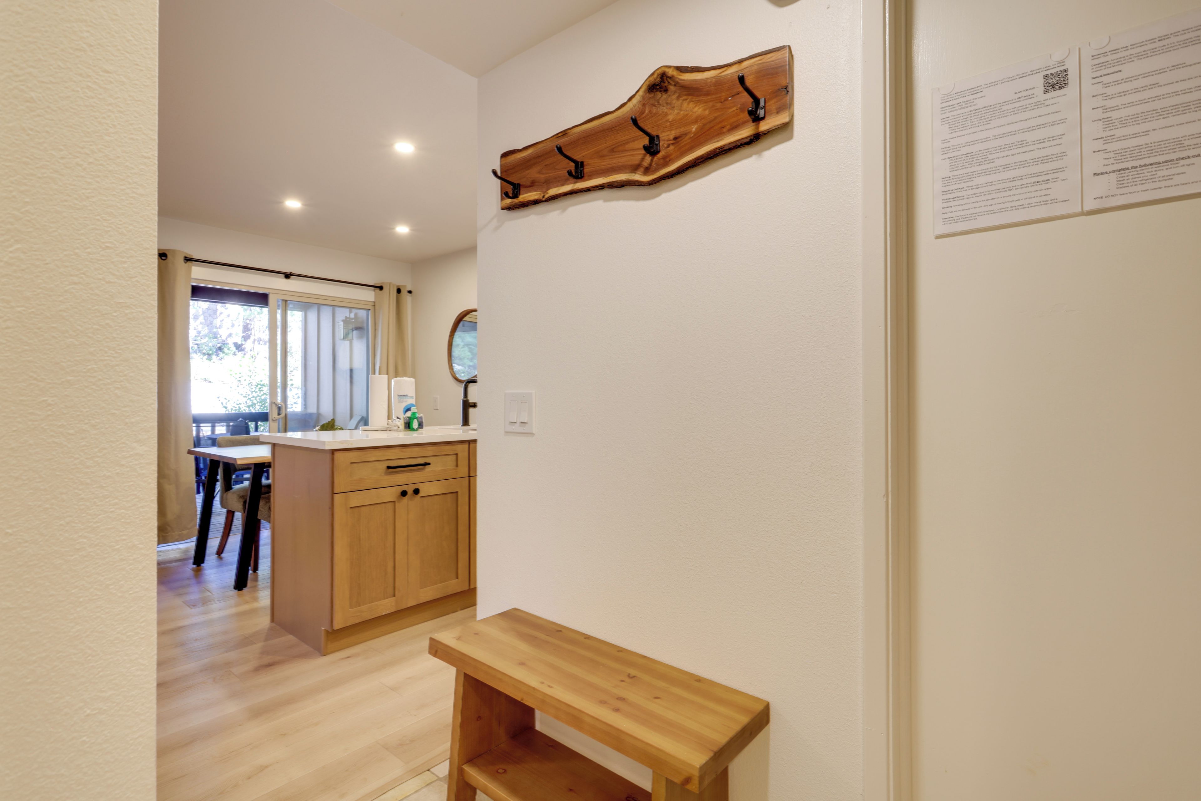 A modern kitchen with wooden cabinets, a countertop, and a wooden bench.
