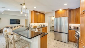 A modern kitchen with wooden cabinets, stainless steel appliances, and a central island. - 30A Poolside Oasis: 2 Mi to Beach & Boat Access (Santa Rosa Beach)