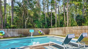 A backyard with a swimming pool, lounge chairs, and a wooden deck. - 30A Poolside Oasis: 2 Mi to Beach & Boat Access (Santa Rosa Beach)