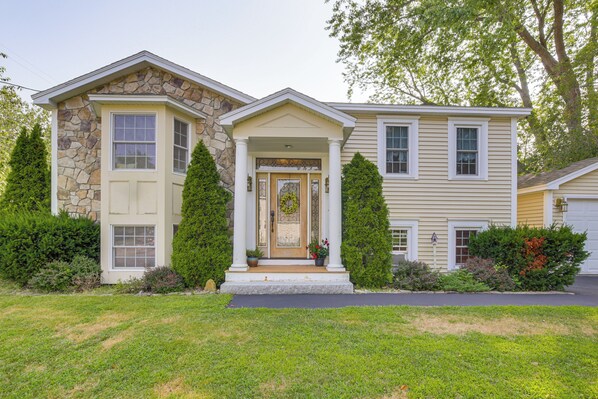 A two-story house with a stone facade, a front porch, and a well-maintained lawn.