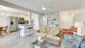 A spacious living area with a sofa, a coffee table, and a kitchen in the background. - 3 Mi to Siesta Key Beach: Condo w/ Heated Pool! (Sarasota)