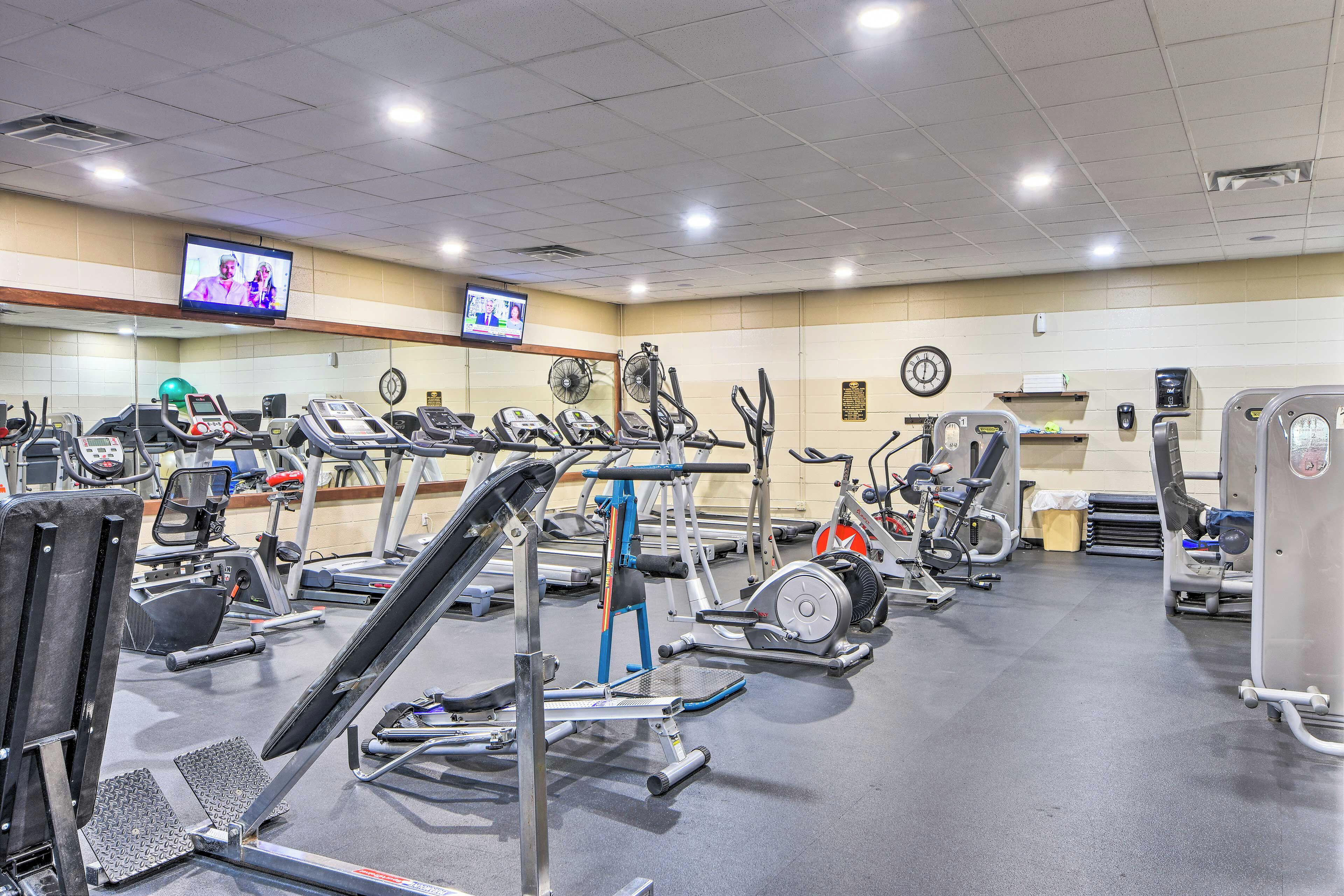 A gym with various exercise equipment, including treadmills, stationary bikes, and weight machines.