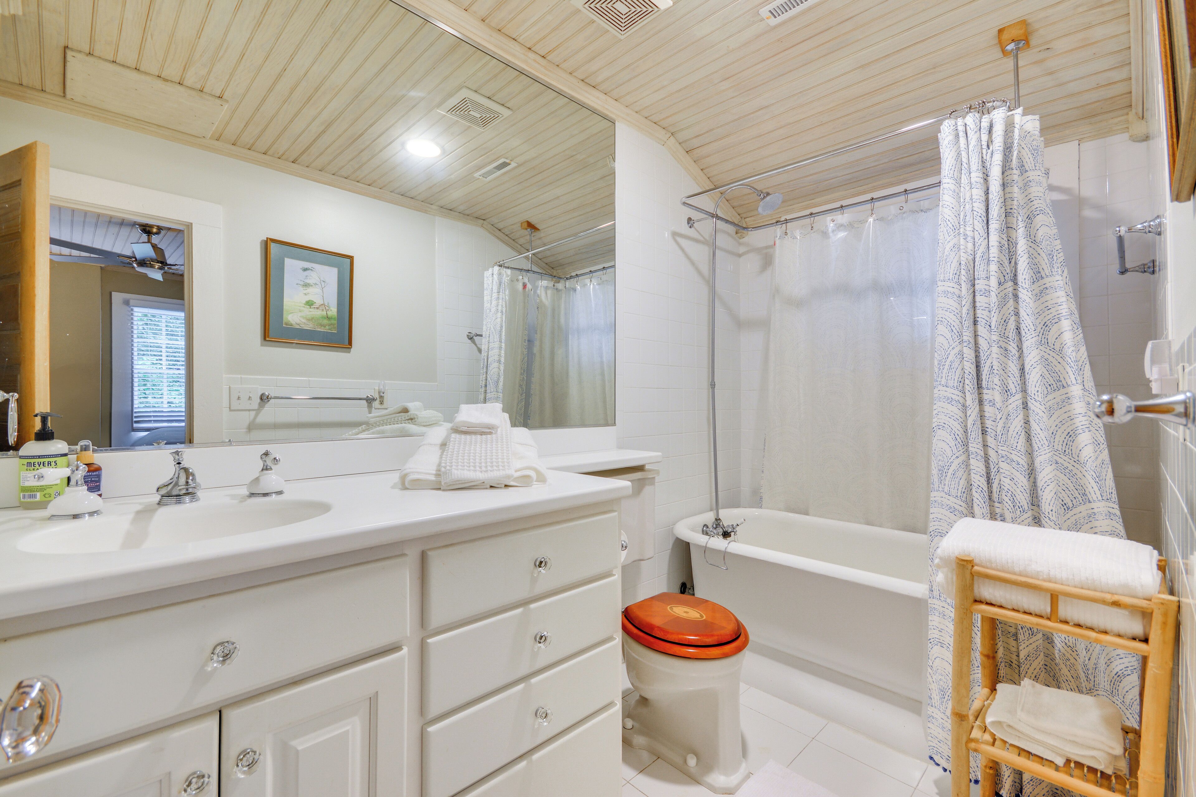 Ein Badezimmer mit weißem Waschtisch, einer Badewanne und einer Duschvorhang.
