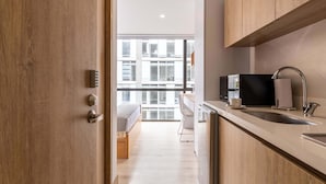 Een moderne keuken met houten kastjes, een roestvrijstalen spoelbak en een zwarte koelkast.