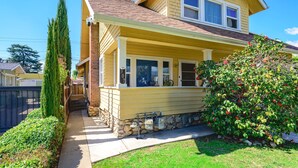 A two-story house with a stone foundation, a front porch, and a well-maintained lawn. - Near LA Cozy Home With Full Kitchen Laundry (San Gabriel)