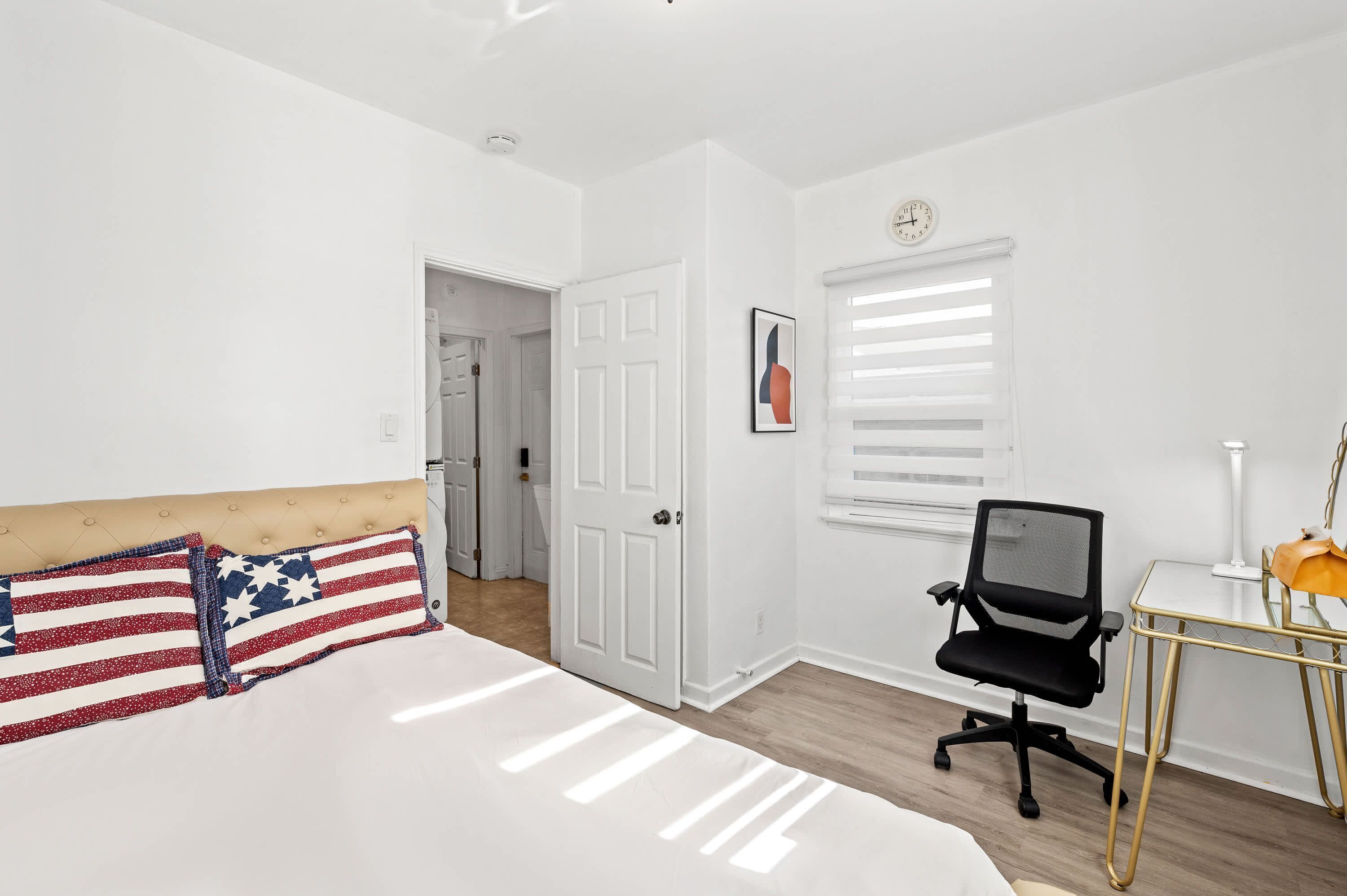 Un dormitorio con una cama, un escritorio y una silla.