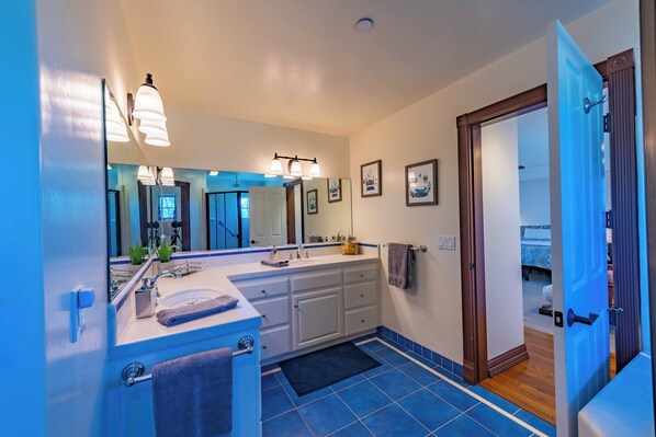 Une salle de bain moderne avec un grand miroir, un lavabo et un meuble-lavabo.
