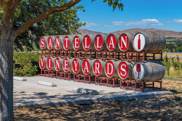Une enseigne pour les vignobles Santellan, avec des barriques en bois et une vue dégagée sur le paysage environnant.
