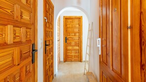 A hallway with wooden doors and a white archway leading to a room. - Apartment 'Vistamar 96' with Sea View, Wi-Fi and Air Conditioning (Benitachell)
