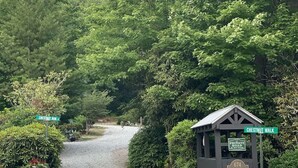 Un camino de grava que conduce a los carteles de Chestnut Run y Chestnut Walk, con Chestnut Cottages y un letrero de camino privado.