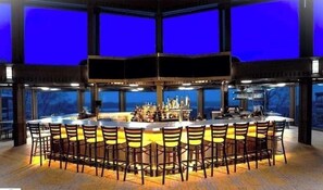 A bar area with multiple seating arrangements and a central bar counter.