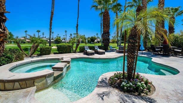 A swimming pool with palm trees, lounge chairs, and a clear blue sky. - PGA West #41 3 BD/3 BA, 2,400 sf - 31+ Night Minimum Bookings Available (La Quinta)