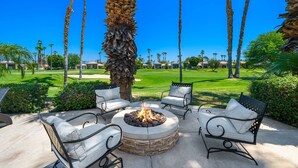A patio with a fire pit, outdoor seating, and a view of a golf course. - PGA West #41 3 BD/3 BA, 2,400 sf - 31+ Night Minimum Bookings Available (La Quinta)