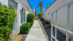 A narrow pathway flanked by white buildings with a clear blue sky above. - PGA West #41 3 BD/3 BA, 2,400 sf - 31+ Night Minimum Bookings Available (La Quinta)