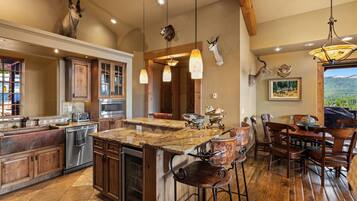 A spacious kitchen with a large island, wooden cabinets, and a dining area with bar stools.