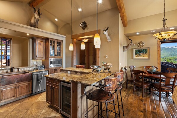 Una cocina amplia con una isla grande, armarios de madera y un comedor con taburetes de bar.