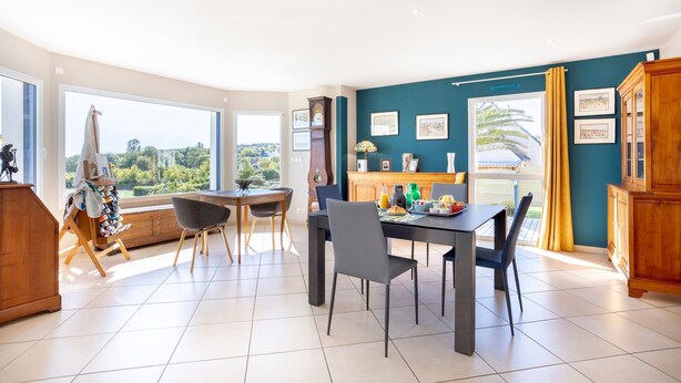 Un coin repas avec une table et des chaises, une fenêtre donnant sur un paysage agréable et un meuble.