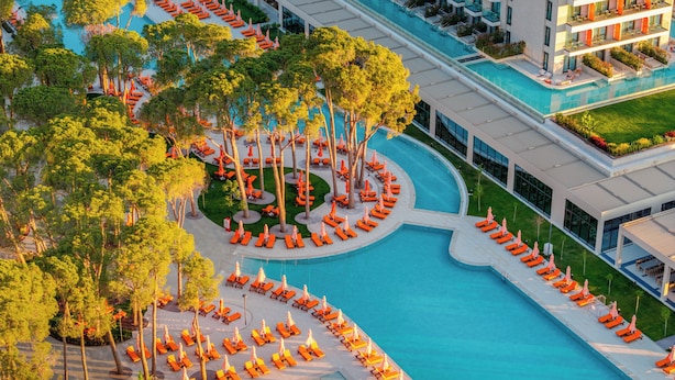 A large swimming pool with multiple sun loungers and trees around it. - Trendy Perge Resort & Suites (Antalya)