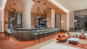 A modern bar area with a curved counter, multiple seating options, and pendant lighting. - Trendy Perge Resort & Suites (Antalya)