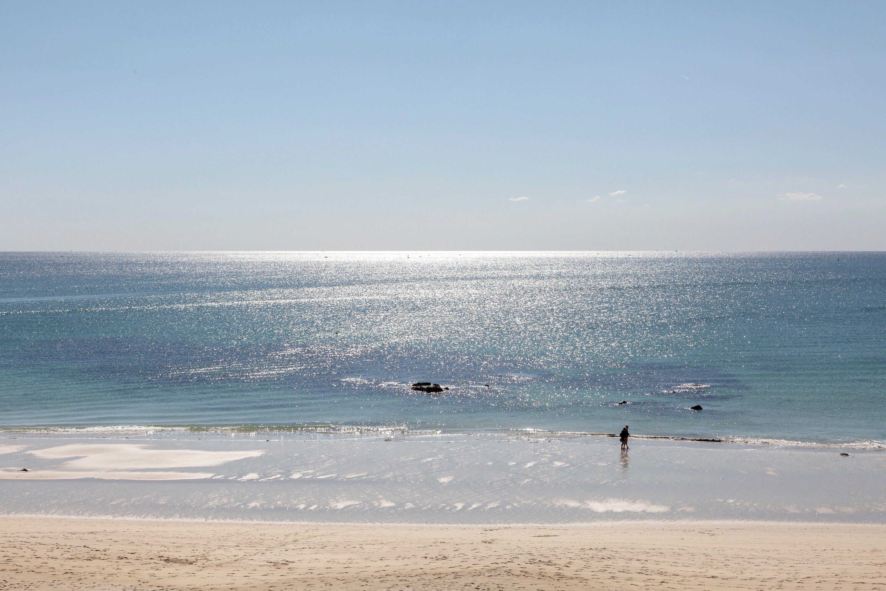 A beach with a clear sky and calm sea.