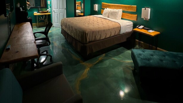 A hotel room with a bed, a desk, a chair, and a small table. - Special boutique hotel in Oxford, Alabama with a variety of themed rooms! (Oxford)