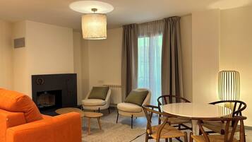 Una sala moderna con sofá, sillas, una mesa de comedor y una chimenea.