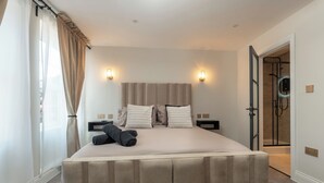 A modern hotel room with a large bed, two bedside tables, and a shower area. - Bold St | King Room | Fireplace | Private Ensuite (Liverpool)
