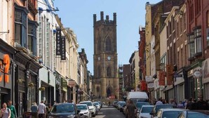 A narrow street lined with historic buildings and a prominent tower in the background. - Bold St | Football & Nightlife | Centre City Stay (Liverpool)