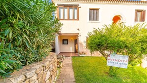 A property with a stone wall, a grassy lawn, and a sign indicating it is for sale. - Three-room apartment "The Flamingos" (Suaredda-traversa)