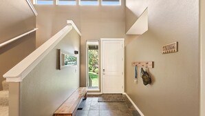 A hallway with a bench, a door, and a small window. - Brighter Days 3 Bedroom Townhouse (Redmond)