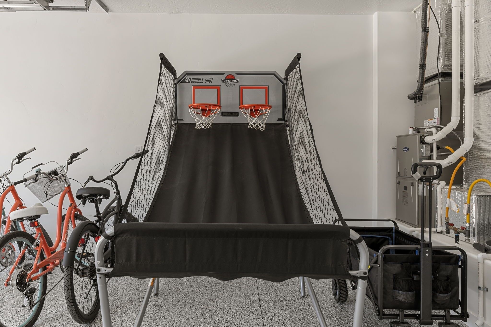 Ein Basketballkorb mit zwei Basketballtafeln, ein Fahrradständer und ein Rollwagen.